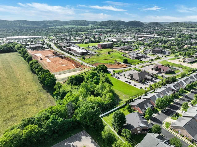 an aerial view of a city with lots of residential buildings and mountain view in back