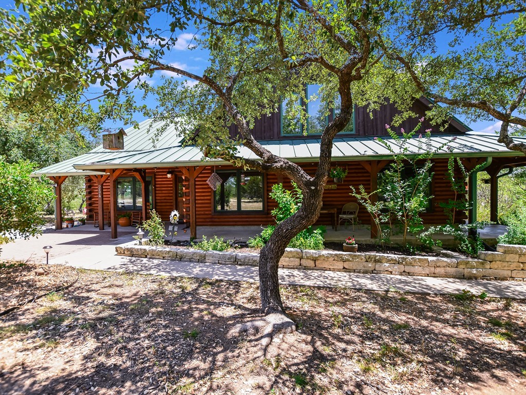 254 Middleton Road Spicewood, TX 78669 - Photo 25 of 32 a patio with a table and chairs under an umbrella