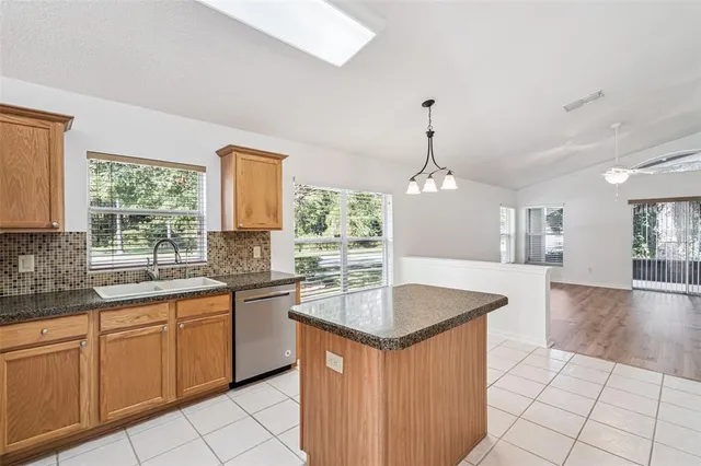 a kitchen with kitchen island granite countertop a sink stove and cabinets