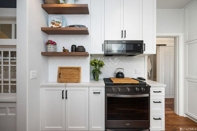 a kitchen with stainless steel appliances a stove and cabinets