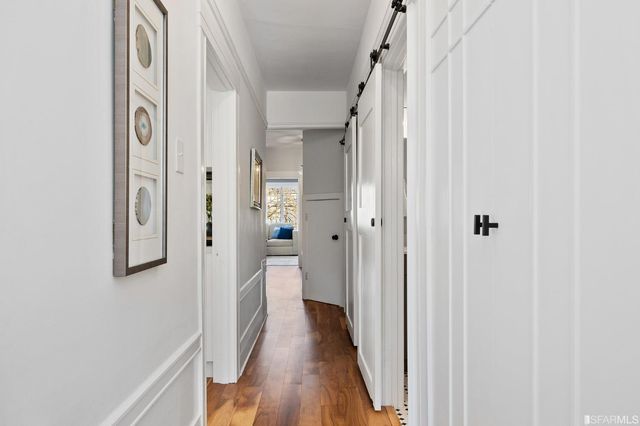 a view of a hallway with wooden floor and staircase
