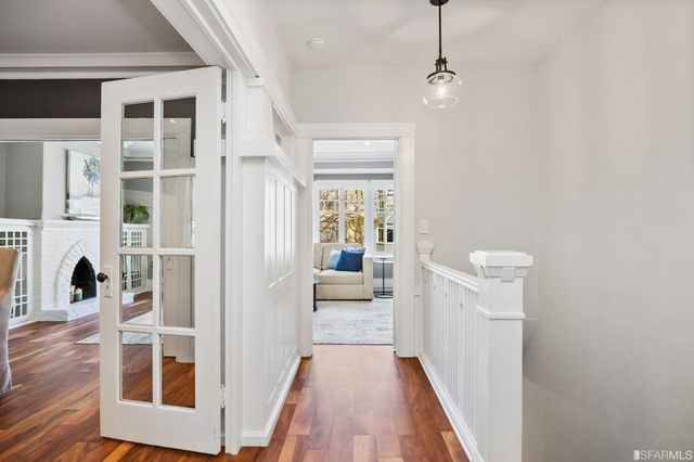 a view of a hallway with wooden floor and staircase