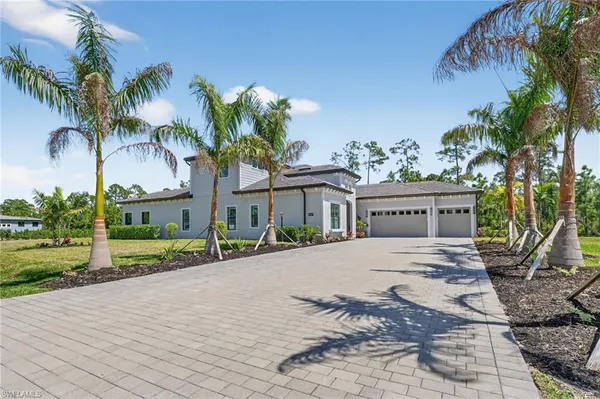 a view of a house with a yard and palm trees
