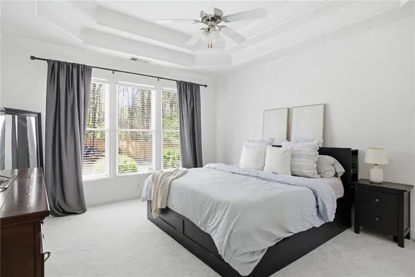 a bedroom with a large bed and a chandelier