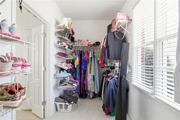 a view of walk in closet with clothes