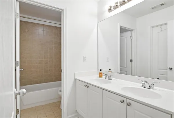 a bathroom with a double vanity sink and a mirror