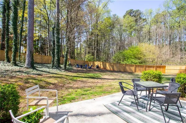a view of swimming pool with lawn chairs and plants
