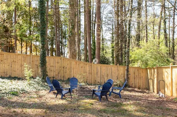 a backyard view with a couple of chairs and potted plants