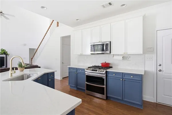 a kitchen with kitchen island a sink appliances and cabinets