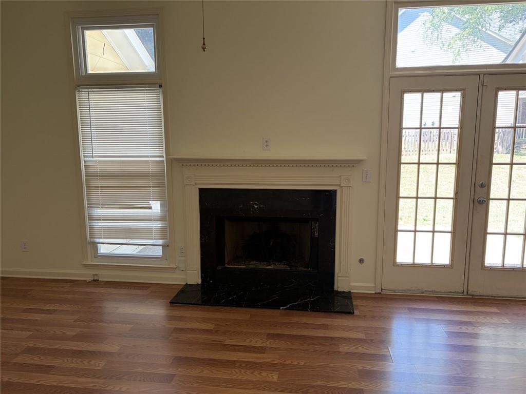 3089 Commons Crossing Snellville, GA 30078 - Photo 3 of 16 an empty room with wooden floor windows and fireplace