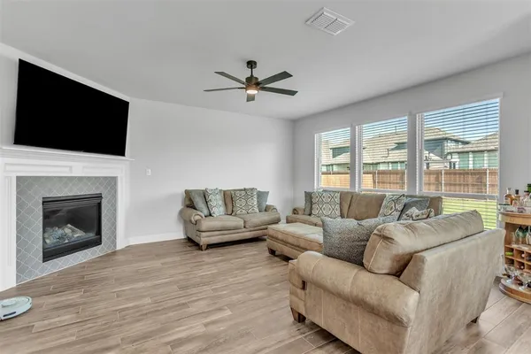 a living room with furniture a fireplace and a flat screen tv