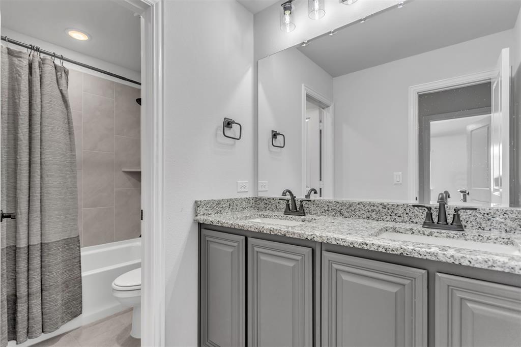 2311 Albion Way Forney, TX 75126 - Photo 19 of 30 a bathroom with a granite countertop sink toilet and shower