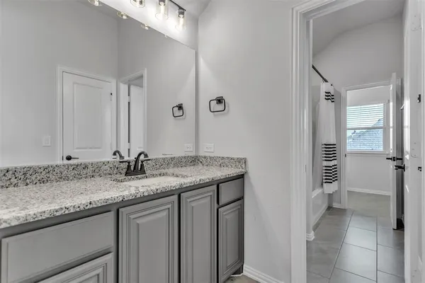 a bathroom with a granite countertop sink and a mirror