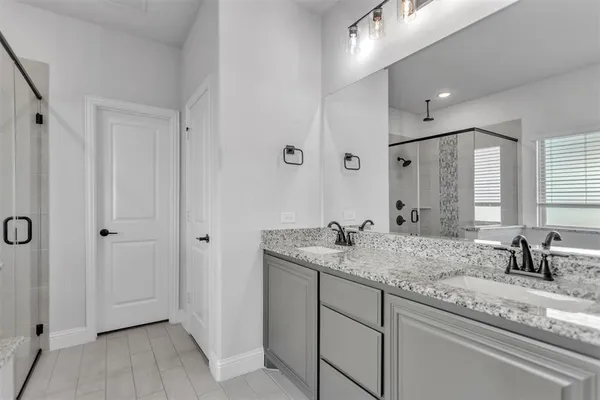 a bathroom with a granite countertop sink a mirror and shower