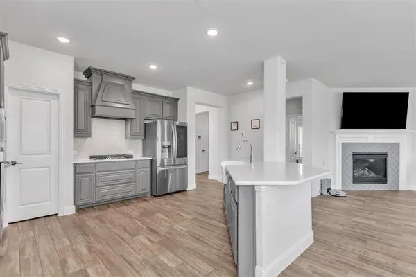 a kitchen with stainless steel appliances kitchen island granite countertop a stove a sink and a refrigerator