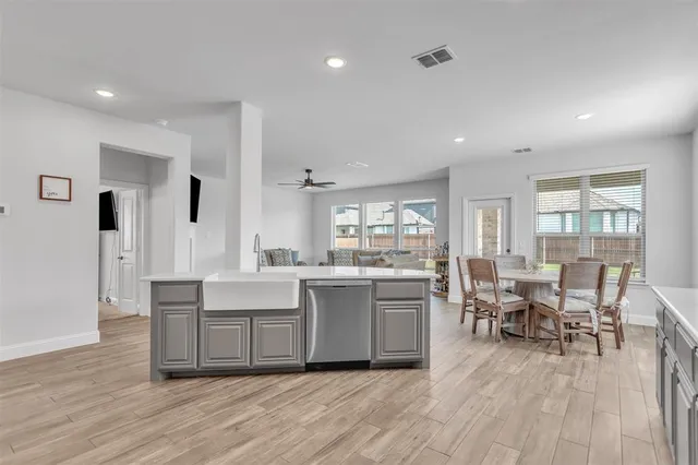a living room with stainless steel appliances granite countertop furniture wooden floor and a view of kitchen