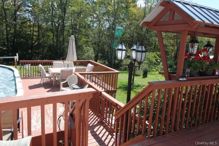 226 Goff Road, Unit 24 Livingston Manor, NY 12758 - Photo 41 of 49 a view of a deck with a table and chairs with wooden floor and fence