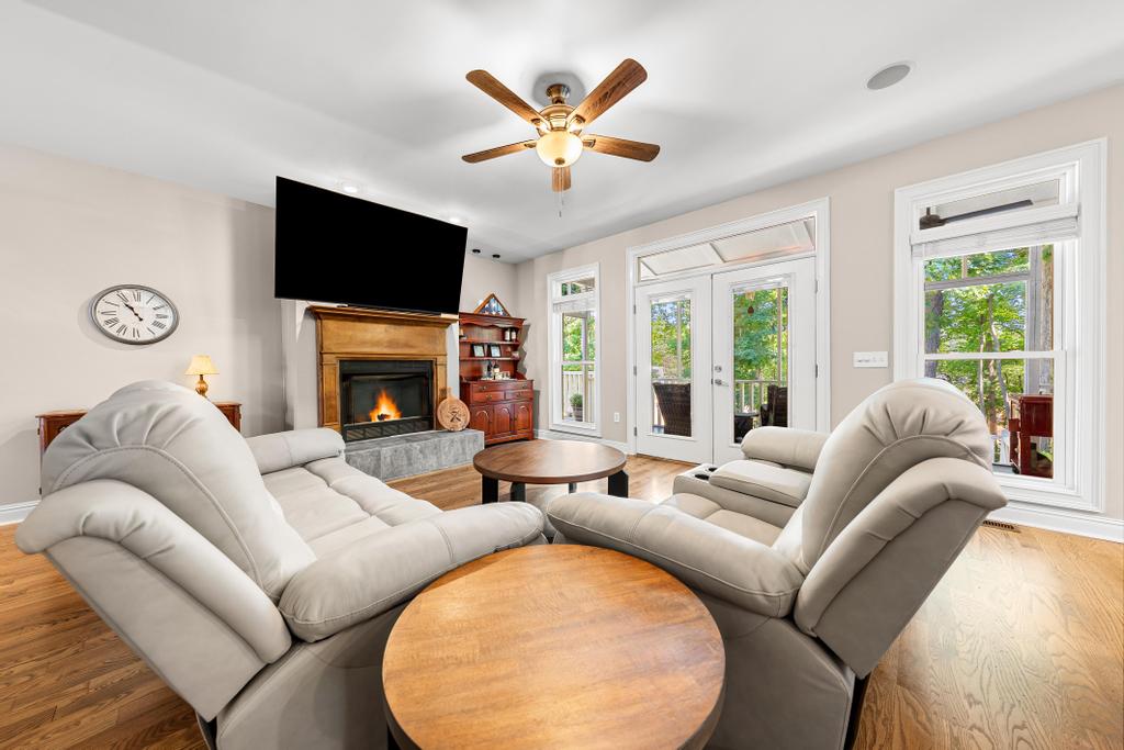 217 Maret Road Townville, SC 29689 - Photo 3 of 35 A comfortable living room featuring a warm fireplace and dual glass doors opening to the covered deck