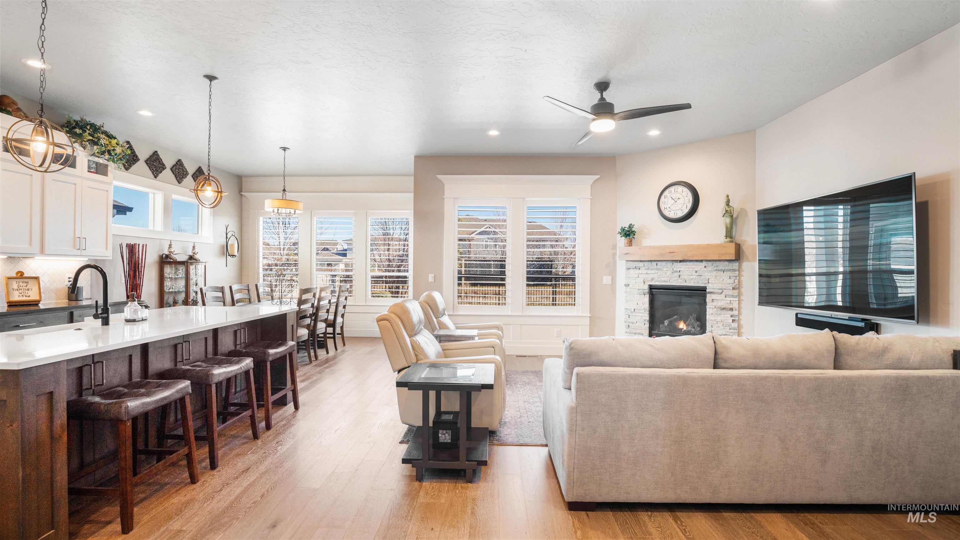 4676 South Abbot Meridian, ID 83642 - Photo 18 of 49 Living room with a stone fireplace, light wood-style floors, a ceiling fan, and recessed lighting