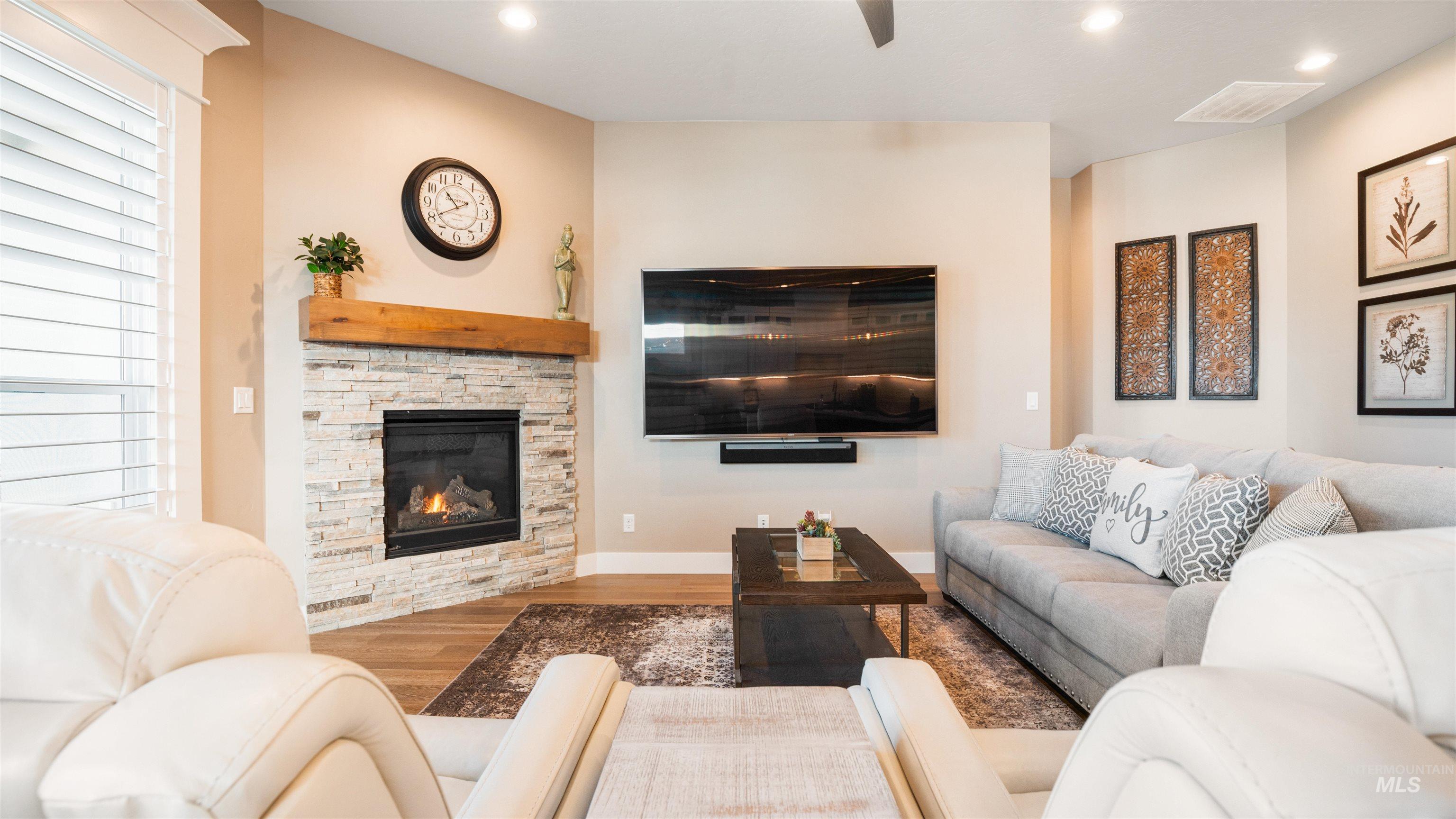 4676 South Abbot Meridian, ID 83642 - Photo 21 of 49 Living room with a stone fireplace, wood finished floors, recessed lighting, and a ceiling fan