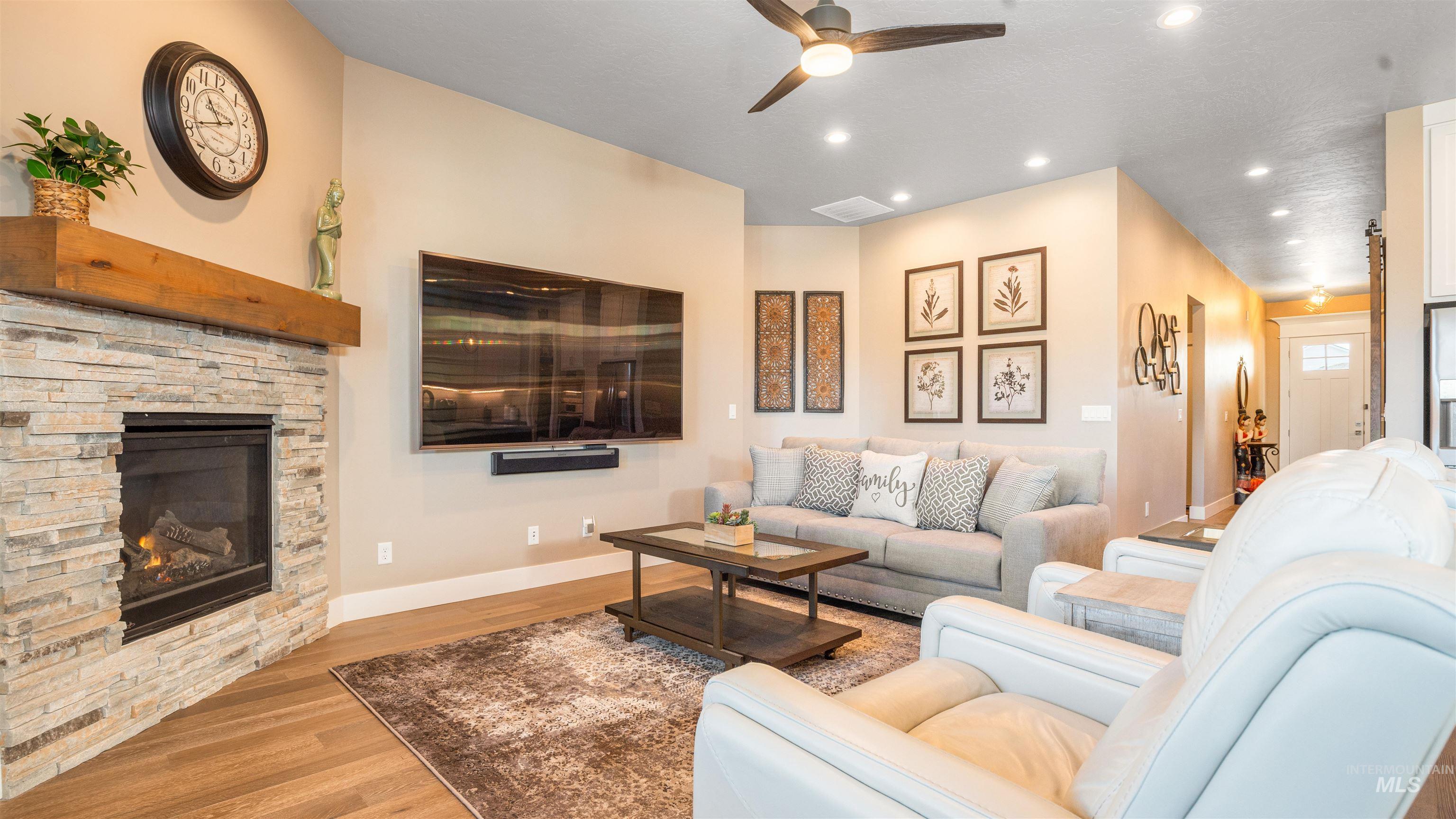 4676 South Abbot Meridian, ID 83642 - Photo 23 of 49 Living room featuring a ceiling fan, wood finished floors, recessed lighting, and a stone fireplace