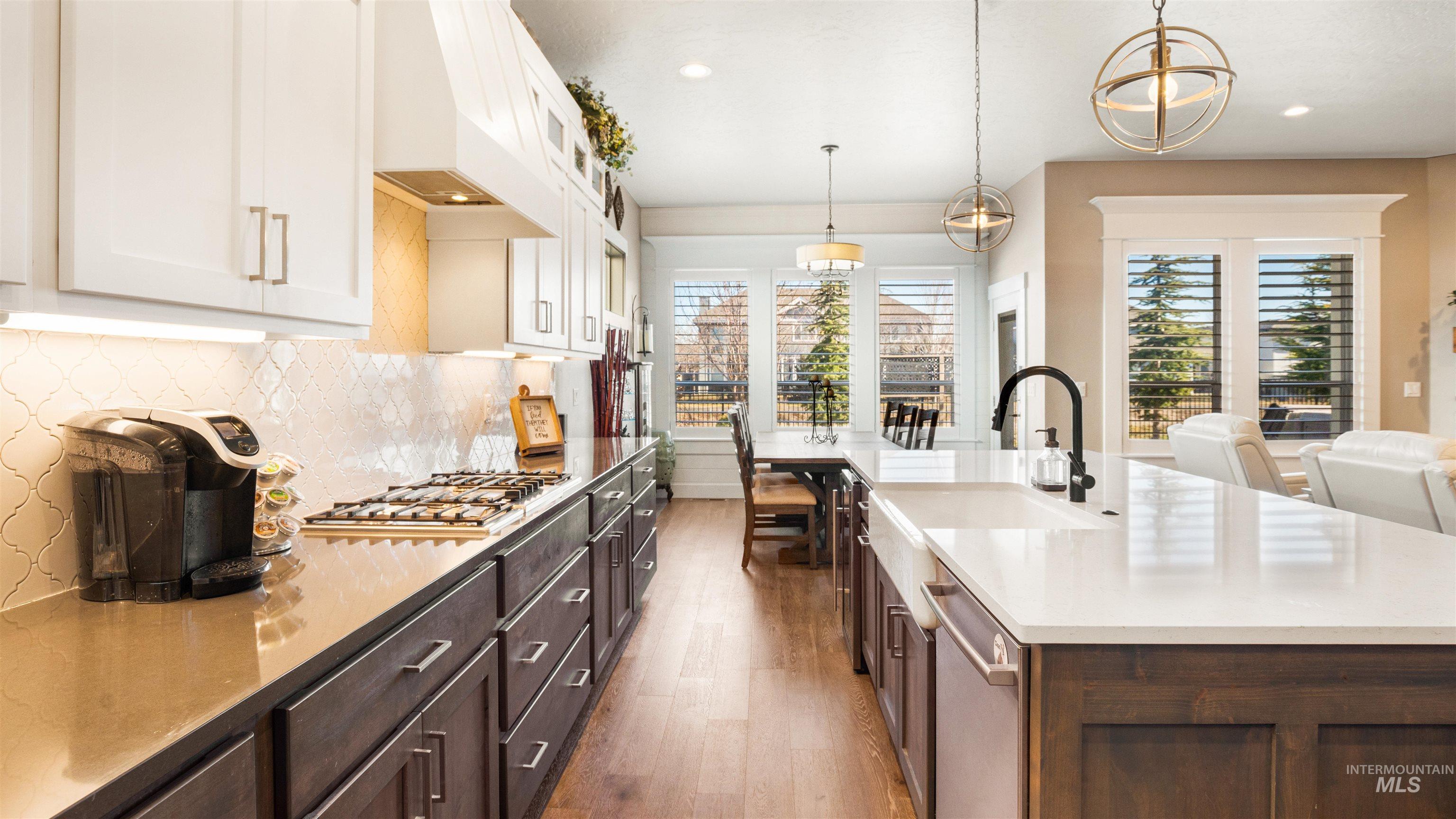 4676 South Abbot Meridian, ID 83642 - Photo 26 of 49 Kitchen featuring two tone color scheme, decorative backsplash, glass fronted cabinets, stainless steel appliances, and dark wood-style floors