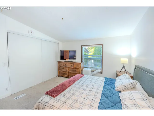 a bedroom with a bed and flat screen tv