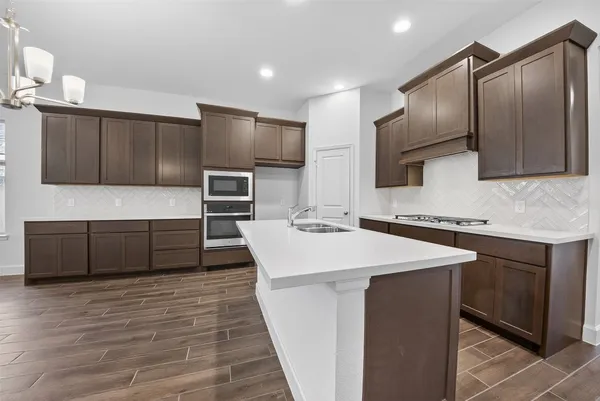 a kitchen with stainless steel appliances kitchen island granite countertop a sink stove and refrigerator