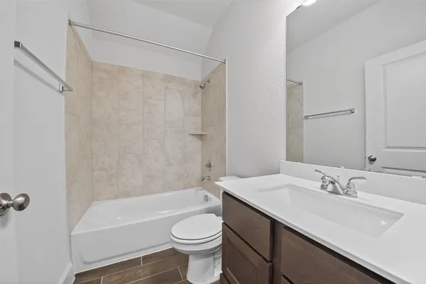 a bathroom with a sink a toilet a mirror a bathtub and shower