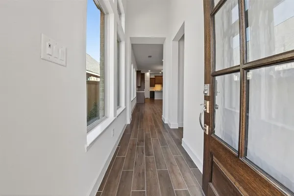 a view of a hallway with wooden floor and staircase