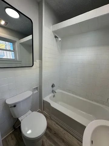 a bathroom with a toilet a sink and bathtub