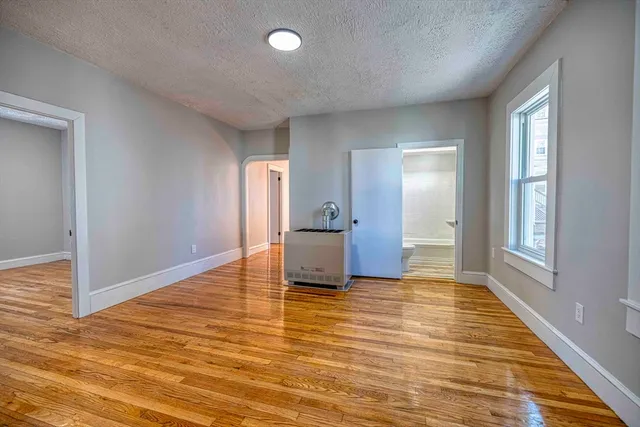 a view of a livingroom with wooden floor and cabinet