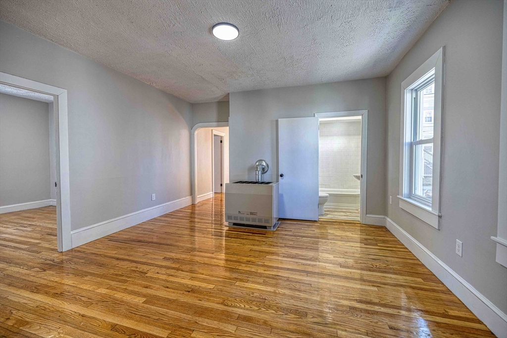 66 Lyon Street, Unit 1 Fall River, MA 02721 - Photo 2 of 11 a view of a livingroom with wooden floor and cabinet