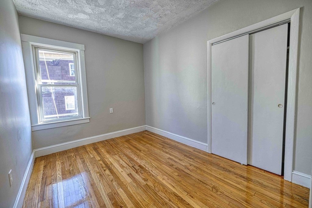 66 Lyon Street, Unit 1 Fall River, MA 02721 - Photo 8 of 11 a view of empty room with wooden floor and fan