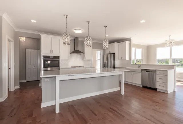 a large kitchen with cabinets wooden floor and stainless steel appliances