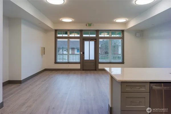 a view of an empty room with a window and wooden floor