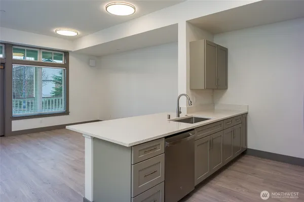 a kitchen with a sink cabinets and wooden floor