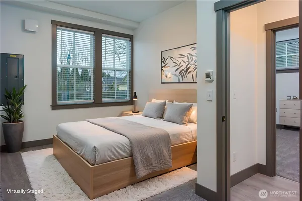 a bedroom with a large bed and a potted plant