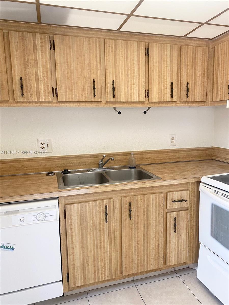 7351 West Sunrise Boulevard, Unit 7351 Plantation, FL 33322 - Photo 18 of 44 a kitchen with stainless steel appliances granite countertop a sink and cabinets with wooden floor