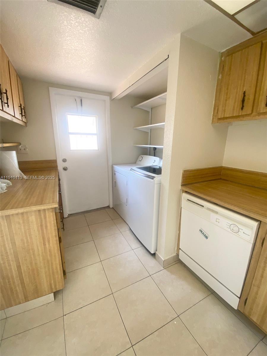 7351 West Sunrise Boulevard, Unit 7351 Plantation, FL 33322 - Photo 20 of 44 a utility room with cabinets washer and dryer