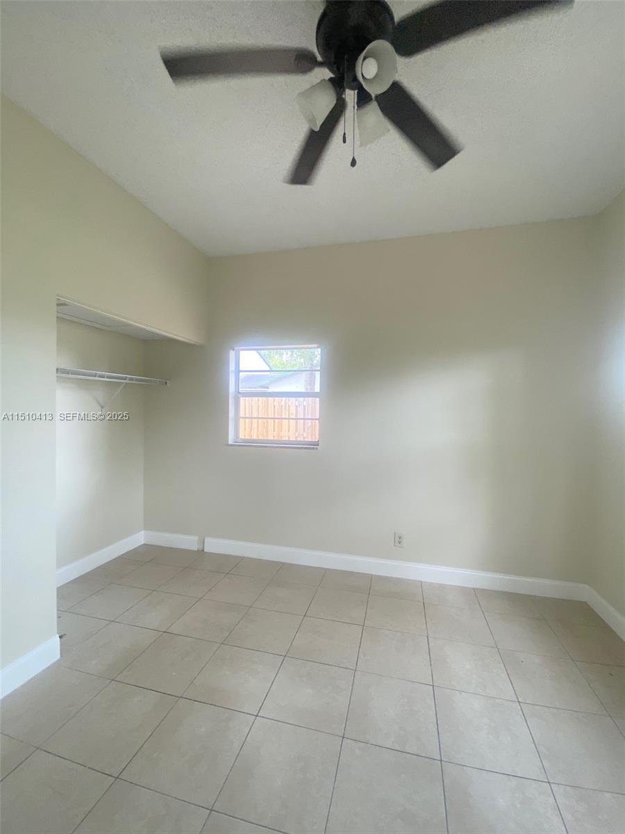 7351 West Sunrise Boulevard, Unit 7351 Plantation, FL 33322 - Photo 30 of 44 an empty room with a ceiling fan and window
