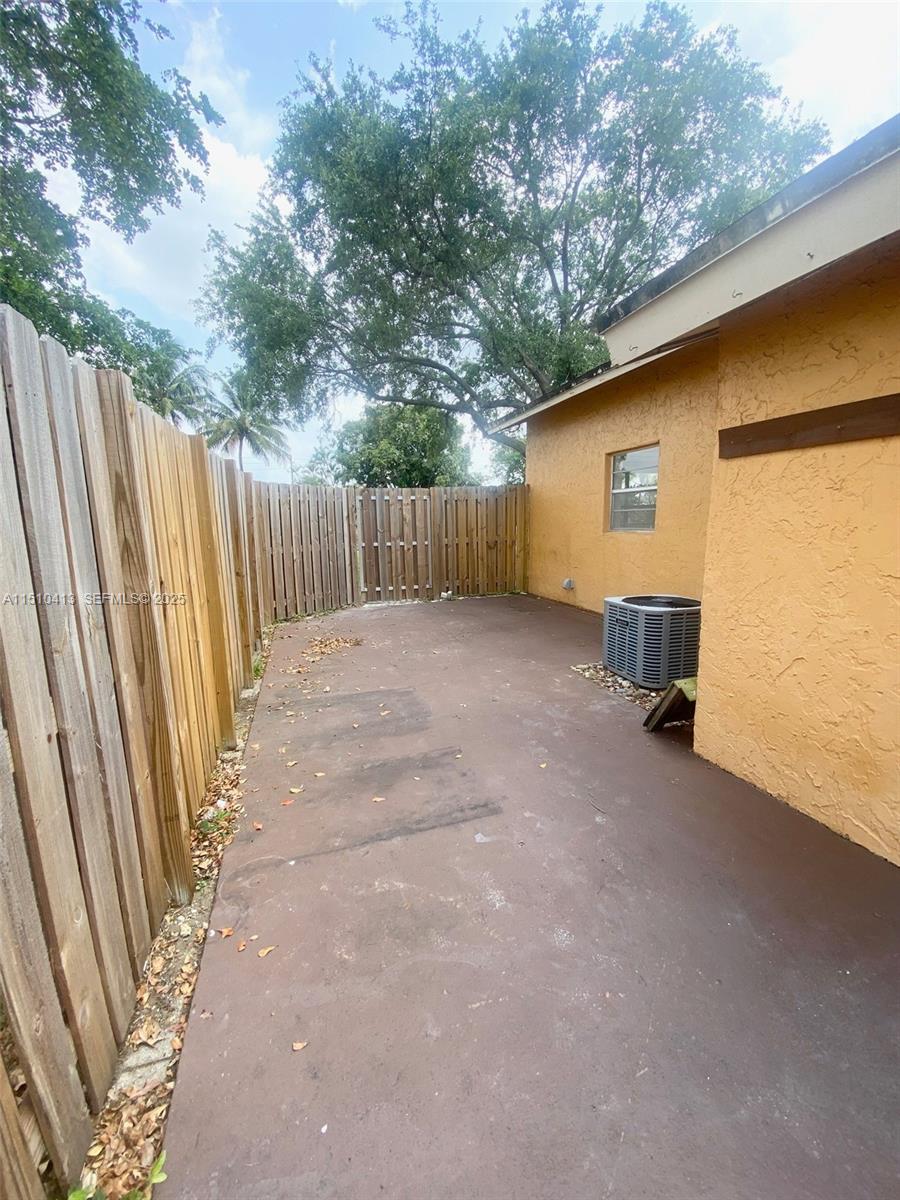 7351 West Sunrise Boulevard, Unit 7351 Plantation, FL 33322 - Photo 34 of 44 a view of a backyard with wooden fence and large trees