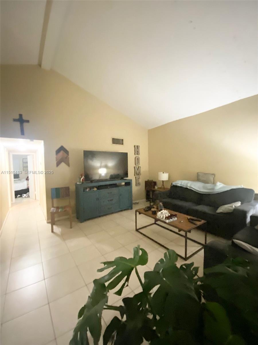 7351 West Sunrise Boulevard, Unit 7351 Plantation, FL 33322 - Photo 9 of 44 a living room with furniture and a flat screen tv