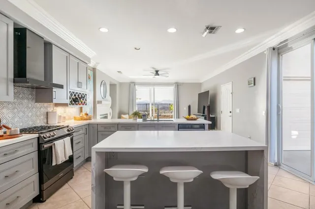 a kitchen with stainless steel appliances granite countertop a table chairs sink and cabinets