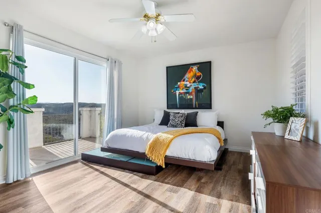 a bedroom with a bed a dresser and wooden floor