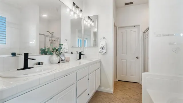 a bathroom with double vanity sinks and a mirror