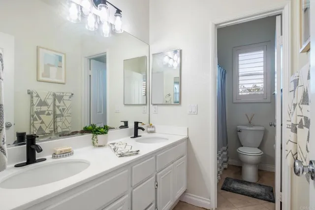 a bathroom with a sink a toilet and a mirror