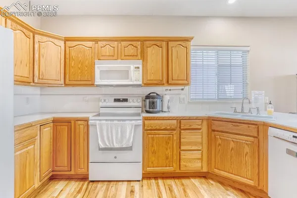 a kitchen with stainless steel appliances granite countertop a sink a stove and a refrigerator