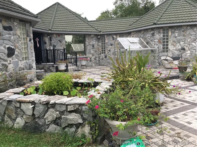 a view of a patio with table and chairs potted plants