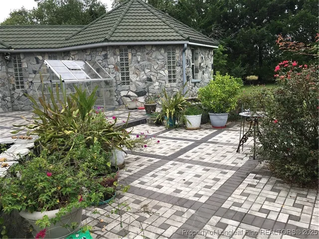 a backyard of a house with wooden fence and plants